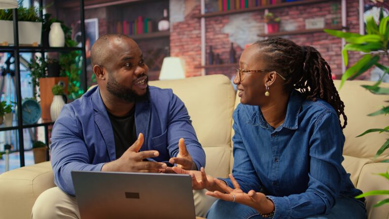African american young freelancers on couch sharing a business idea